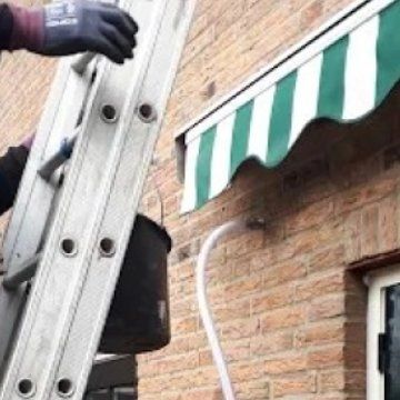 Spouwmuur vullen via een slang door een boorgat in de gevel