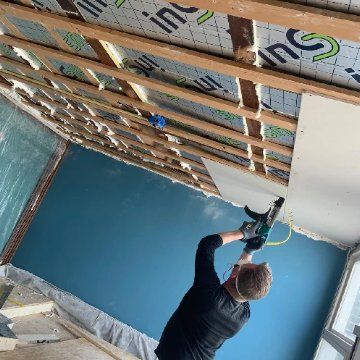 Monteur van Iso Concurrent isoleert een zolder aan de binnenkant van het dak
